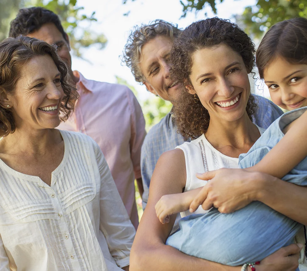Mother-carrying-daughter-in-arms-with-family